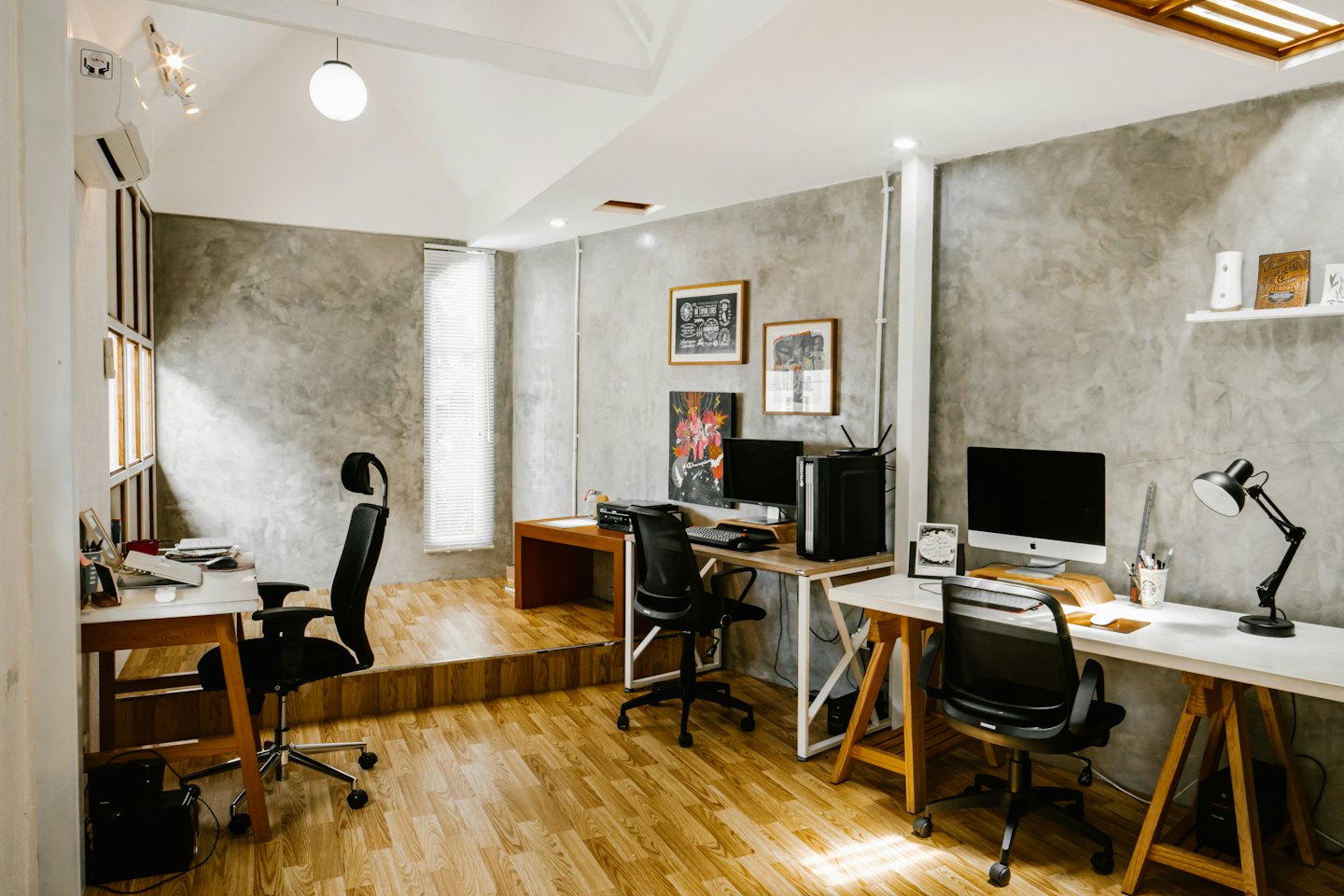 Modern empty office with minimalist workstations and wooden floors.